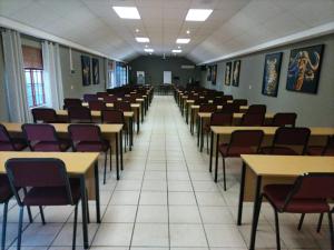a room full of tables and chairs in a classroom at Eskulaap Hotel in Polokwane