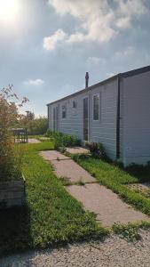 a white building with a pathway next to it at Alloro-cat in Hem +11 photos