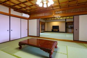 a large room with a table in the middle of it at Ooedo Onsen Monogatari Premium Yamashitaya in Kaga