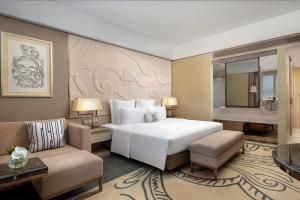 a bedroom with a large white bed and two chairs at Grand Pacific Hotel Ningbo in Yuyao +30 photos