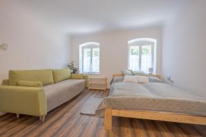 a living room with a bed and a couch at Döbrögi Wellness Vendégház in Nemesvita +30 photos