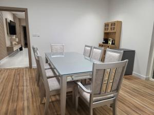 a dining room with a glass table and chairs at Hatta Orchard in Hatta