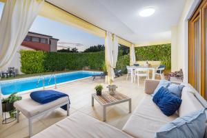 a patio with a couch and a table and a pool at House with pool and whirlpool in Sarići
