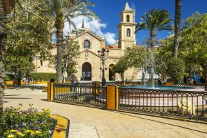a gate in front of a building with a church at Apartment Pink Vistalegre in Torrevieja