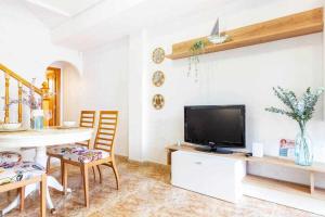 a living room with a tv and a table and chairs at Bungalow Pink Punta Prima in Alicante
