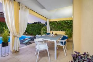 a patio with a table and chairs and a pool at House with pool and whirlpool in Sarići