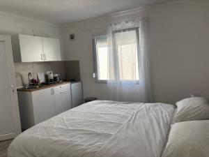 a white bedroom with a bed and a window at White Rose 2 in Bar