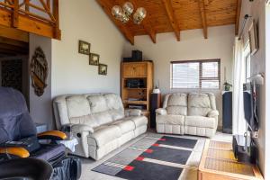 a living room with two couches and a tv at Bon A Vie Self-catering and b&b Gonubie Full Solar Power, no load shedding! in Gonubie
