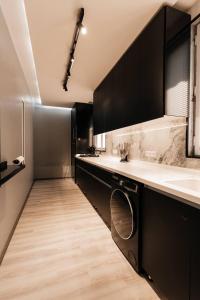 a kitchen with black cabinets and a sink at Modern Canadian Style Unit in Tashkent +39 photos