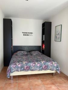 a bedroom with a bed with a poster on the wall at Hacienda in Caumont