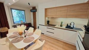 a kitchen with a table and chairs in a room at Silver Lake Apartman in Balatonboglár