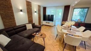 a living room with a couch and a table at Silver Lake Apartman in Balatonboglár