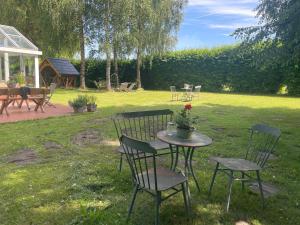 a table with two chairs and a table with flowers on it at Dorfstübli - gemütliche und ruhige Zimmer in Ortsrandlage in Alt Schönau