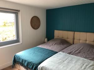 a bedroom with a bed with a blue wall at Bienvenue à Evian in Neuvecelle