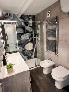 a bathroom with a toilet and a shower and a sink at Victry's Houses Chiaia in Naples