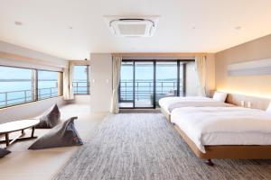 a hotel room with two beds and a large window at TAOYA Wakura in Nanao