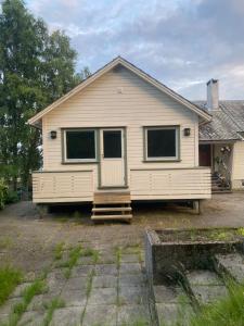 a white house with a front porch and a door at Appartment in Jørpeland