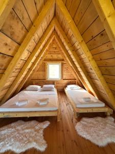 two beds in a room in a log cabin at Retreat Komovi in Andrijevica