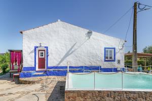 a large white building with a pool in front of it at Monte Corte Enchária in São Teotónio