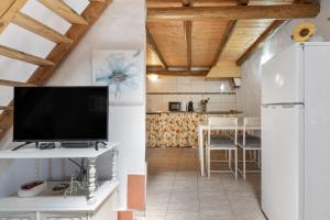 a kitchen and living room with a tv and a refrigerator at Monte Corte Enchária in São Teotónio