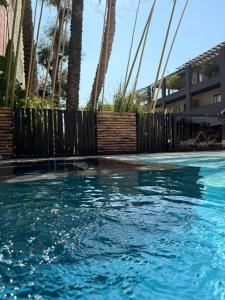 a swimming pool with blue water and palm trees at Paradisea club and residences in Volla