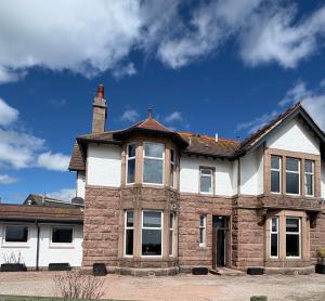 a large brick house with a chimney at St Olaf Golf Hotel in Cruden Bay