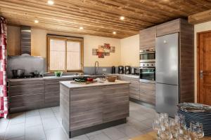a kitchen with stainless steel appliances and wooden ceilings at Chalet Snow Mountain in Le Bettaix +8 photos