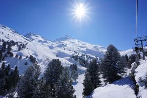 a snow covered mountain with the sun in the sky at Chalet Snow Mountain in Le Bettaix
