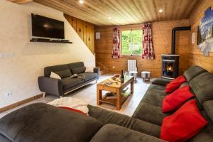 a living room with a couch and a tv at Chalet Snow Mountain in Le Bettaix