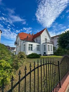 a white house with a fence in front of it at Willa Ingeborg in Międzyzdroje