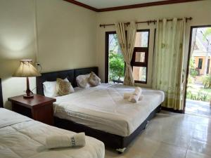 a bedroom with two beds and a window at Tom Pizza Resort in Ko Samed