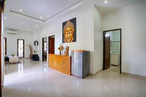 a large living room with a statue of a head on the wall at Kubu Kapas Bali in Ubud +101 photos