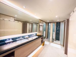 a bathroom with a sink and a large mirror at Formosan Naruwan Hotel in Taitung City