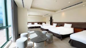 a hotel room with four beds and a table at Formosan Naruwan Hotel in Taitung City +84 photos