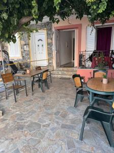 a patio with tables and chairs on a stone floor at Stella Studios in Ilia