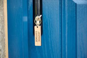 a tag on a blue container with a key on it at Jasmine Cottage - Sands Farm in Wilton