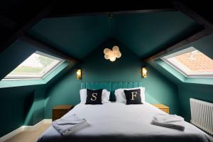 a bedroom with green walls and a bed with pillows at Jasmine Cottage - Sands Farm in Wilton
