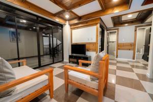 a living room with two chairs and a flat screen tv at Highland Nest in Baguio