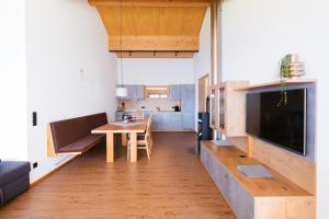 a living room with a dining table and a television at Alpenpanorama Konzett Faschina in Fontanella