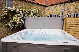 a large bath tub sitting in front of a building at Jasmine Cottage - Sands Farm in Wilton