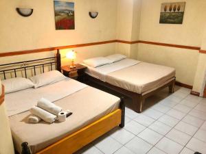 a bedroom with two beds and a lamp in it at Marian Palazz Hotel in Baguio