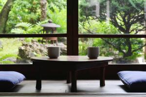 two cups on a table in front of a window at ann長良 Machiya Private Villa ann Nagara 築130年古民家で長良川と岐阜城を満喫 無料駐車場4台完備 無人チェックイン in Gifu