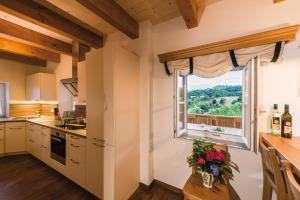 a kitchen with a window and a table with flowers at Weinquartier Pichler-Schober in Mitteregg
