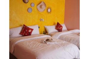 a room with two beds with a cat sitting on top of them at Marian Palazz Hotel in Baguio +26 photos