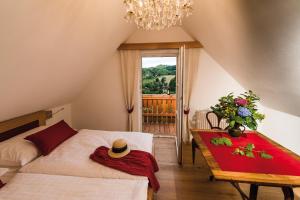 a bedroom with a bed and a table with a hat on it at Weinquartier Pichler-Schober in Mitteregg