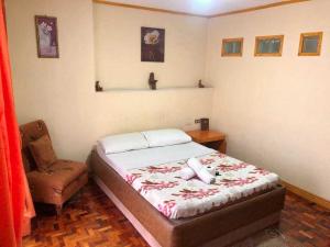 a bedroom with a bed and a chair in it at Marian Palazz Hotel in Baguio
