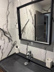 a bathroom with a sink and a mirror at ღ L'Urban Gare - T3 Cosy Parking & Wifi in Douai