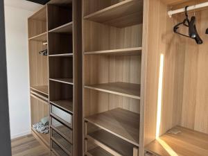 a walk in closet with wooden shelves at ღ L'Urban Gare - T3 Cosy Parking & Wifi in Douai