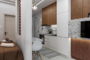 a kitchen with white cabinets and a bed in a room at Elite Suite in Xanthi +13 photos