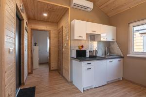 a kitchen with white cabinets and a microwave at DOMKI#ENERGY Zator in Przeciszów +60 photos